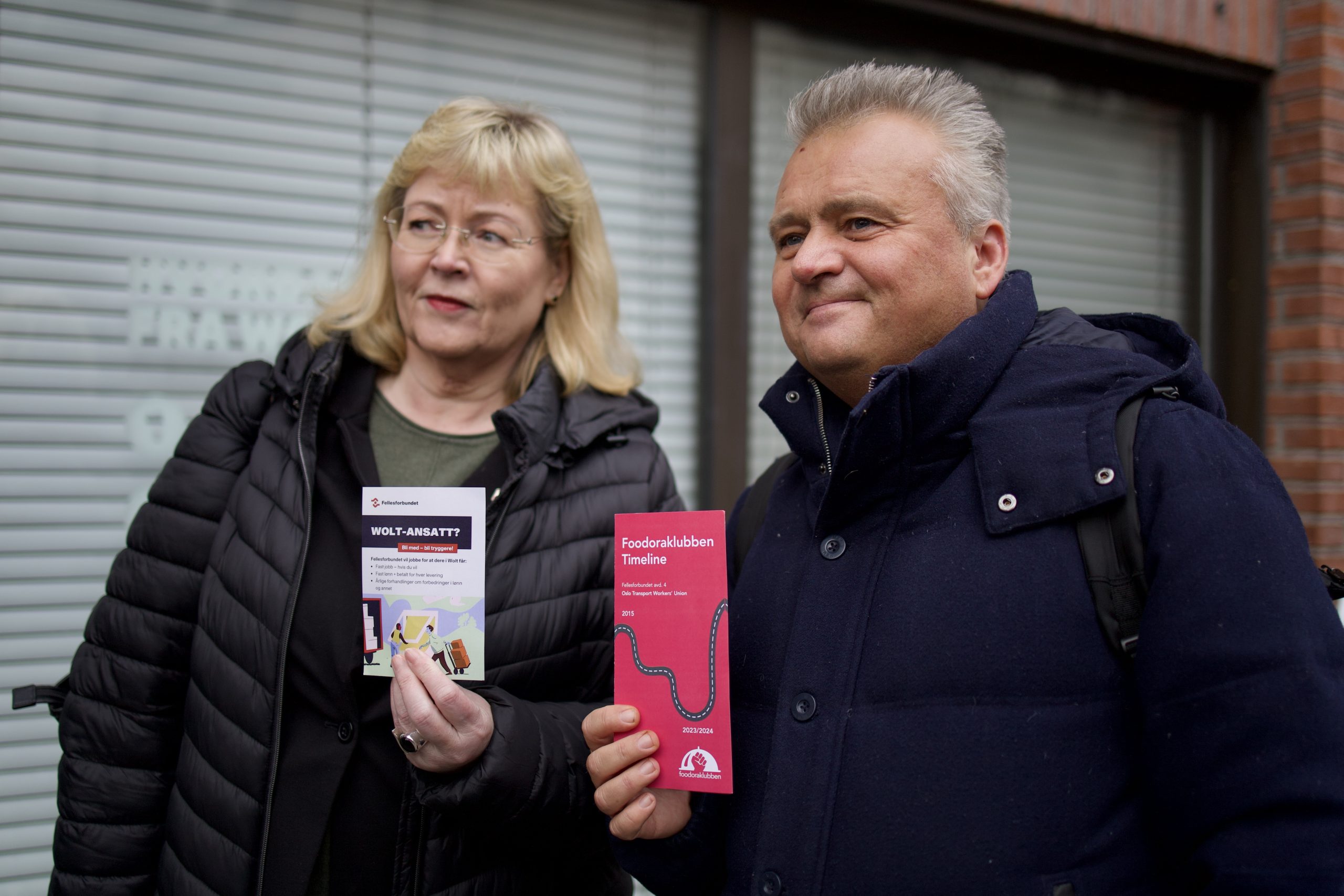 Trude Tinnlund og Jørn Eggum fra henholdsvis LO og Fellesforbundet i gang med utdeling av løpesedler til Wolt-sjåførene.